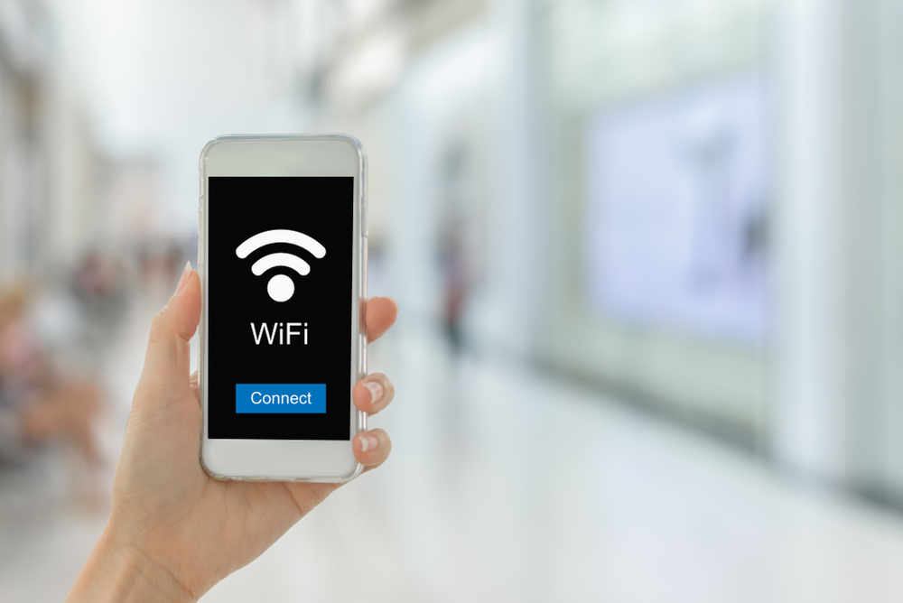 Close,Up,Woman,Hand,Hold,Smartphone,Connection,To,Public,Wifi Facebook WIFI: What It Is and Why Your Business Needs It